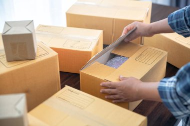 Kadın çevrimiçi mağazanın yakın görüntüsü küçük işletme sahibi satıcı girişimci paketleme paketi posta kutusu hazırlık teslimat paketi.