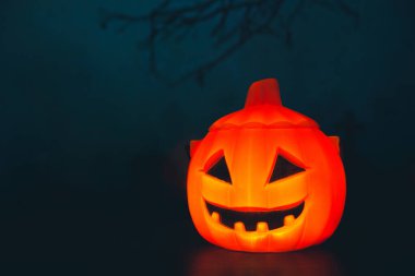 Cadılar Bayramı balkabağı kafalı, yanan mumları olan bir fener. Ürkütücü bir gecede mezarlıkta balkabakları - Cadılar Bayramı arkaplanı