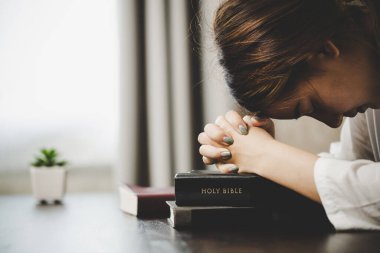 Dua eden bir kadın inanır. Yumuşak odaklanma, dua etme ve evde birlikte dua etme. adanmışlık ya da dua toplantısı kavramı.