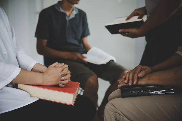 Group of people are reading the bible. soft focus, praying and praise together at home. devotional or prayer meeting concept.