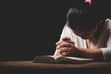 Kilisede dua eden ve ibadet eden Hristiyan kadınlar siyah arka planda, yetişkin kadınlar kitap, inanç, maneviyat ve din kavramlarını okuyorlar.