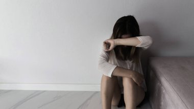 Young person woman sad, stress and loneliness sitting in dark room, Unhappy and crying teenage girl from domestic violence, An adult female expresses feelings of despair, anxiety from harassment.