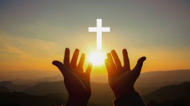 Silhouette of human hands palm up praying and worship of cross, eucharist therapy bless god helping, belief, forgiveness, freedom, hope and faith, christian religion concept on sunset background.