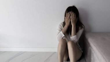 Young person woman sad, stress and loneliness sitting in dark room, Unhappy and crying teenage girl from domestic violence, An adult female expresses feelings of despair, anxiety from harassment.
