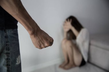 Man beating up his wife illustrating domestic violence. Fear and crying woman beats husband's abuse. sad and hopeless woman sitting in dark room concept of social problems.