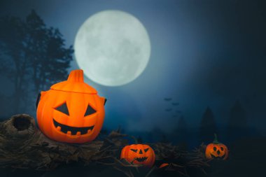 Cadılar Bayramı balkabağı kafalı, yanan mumları olan bir fener. Ürkütücü bir gecede mezarlıkta balkabakları - Cadılar Bayramı arkaplanı