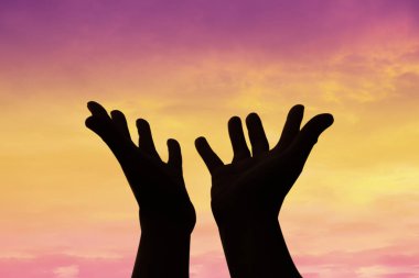 Person human hands open palm up worship or pray for god. background is sunrise. Concept for Christian, Christianity, Catholic religion, divine, heavenly, celestial or god.