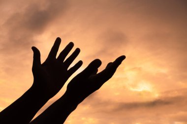 Person human hands open palm up worship or pray for god. background is sunrise. Concept for Christian, Christianity, Catholic religion, divine, heavenly, celestial or god.