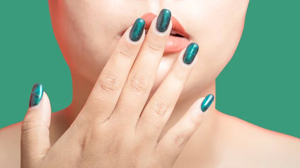 Female hand with green nail design on green background. Woman manicure is art beautiful summer style. Close-up of healthy young girl beauty fingers.