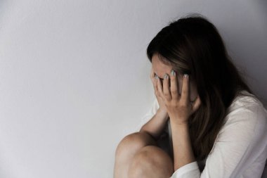 Young person woman sad, stress and loneliness sitting in dark room, Unhappy and crying teenage girl from domestic violence, An adult female expresses feelings of despair, anxiety from harassment.