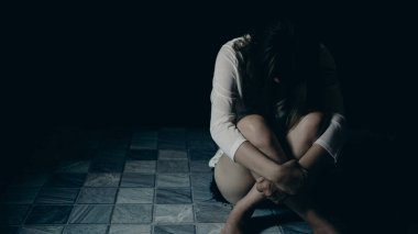 Young person woman sad, stress and loneliness sitting in dark room, Unhappy and crying teenage girl from domestic violence, An adult female expresses feelings of despair, anxiety from harassment. clipart
