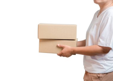 A parcel cardboard parcel box in a delivery woman person hands isolated on white background. Delivery service concept. Asian Young girl holding a package is a delivery business entrepreneur.