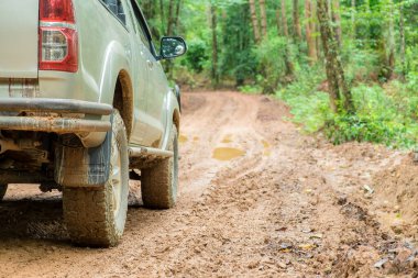 Wheel truck closeup in countryside landscape with muddy road. Extreme adventure driving 4x4 vehicles for transport or travel or off-road races in outdoor nature. 4wd tire automobile on dirt mountain.