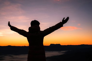 Silhouette of human person hands open palm up worship in sky sunset or sunset. Catholic adult man pray and hope on mountain. Christian religion concept background. fighting and victory for god