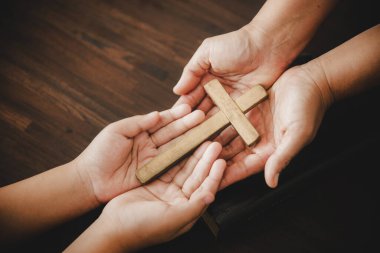 Cross in hand prayer to god on dark in church concept for faith spirituality and religion woman person praying on holy bible in morning. Christian catholic woman hand with worship in black background.