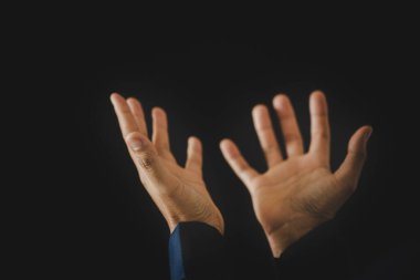 Hand folded prayer to god on dark in church concept for faith, spirituality and religion, woman person praying on holy bible in morning. Christian catholic woman hand with worship in black background.