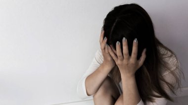 Young person woman sad, stress and loneliness sitting in dark room, Unhappy and crying teenage girl from domestic violence, An adult female expresses feelings of despair, anxiety from harassment.