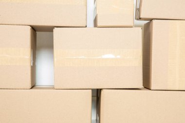Stack of cardboard boxes for moving, Empty room with a white wall and cardboard boxes with unbranded barcode on the floor. Delivery of goods, shopping. Cardboard boxes on gray wall background.