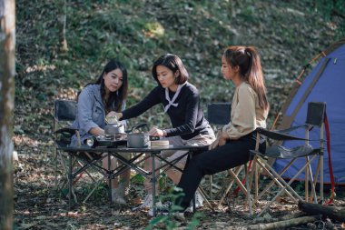 Bir grup arkadaş ormanda kamp yapar ve doğada yemek pişirir..