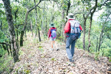Young tourist couple watching spectacular mountain scenery in high mountains. man and woman hiker on top rock. A couple of travelers in love. People greet the dawn. Lovers travel. Copy space