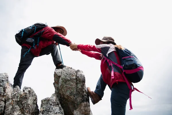 Person hike friends helping each other up a mountain. Man and woman giving a helping hand and active fit lifestyle. Asia couple hiking help each other. concept of friendship, teamwork.