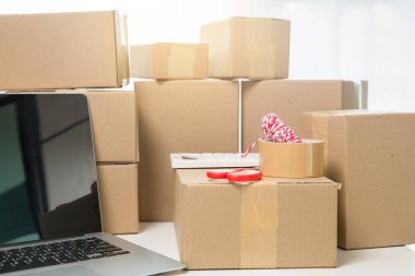 KOBİ 'nin internet işleri, teslimat bilgisayarları, barkodlar, kutular, hisse senetleri ve karton paketlerdeki ürünleri kontrol etmek için gerekli malzemeler. Ev ofisinde çalışan küçük bir işletme. teslimat hizmeti ürünü evde.