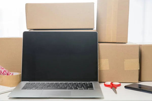 Equipments for SME online business, delivery business laptop, barcode, boxes, checking product on stocks or cardboard parcels. Small business working at home office. delivery service product at home.