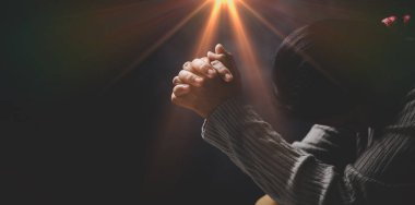 İsa dini ve Hıristiyanlık ibadeti ya da dua kavramı. Hıristiyan katolik kadın kilisede karanlıkta Tanrı 'ya dua ediyor. Dua eden kişi siyah arka planda. Kız İsa 'ya inanıyor ve inanıyor..