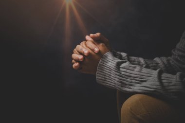 İsa dini ve Hıristiyanlık ibadeti ya da dua kavramı. Hıristiyan katolik kadın kilisede karanlıkta Tanrı 'ya dua ediyor. Dua eden kişi siyah arka planda. Kız İsa 'ya inanıyor ve inanıyor..