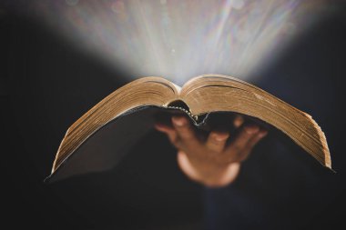 Evde ders çalışarak İncil 'i tutan genç bir kadın. Kilisede yetişkin bir Hıristiyan kadın kitap okuyor. Din maneviyatını Tanrı 'ya dua ederek öğrenen bir kız. Öğrenci eğitimi inancı kavramı.