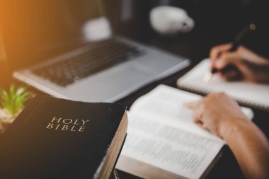 Evde ders çalışarak İncil 'i tutan genç bir kadın. Kilisede yetişkin bir Hıristiyan kadın kitap okuyor. Din maneviyatını Tanrı 'ya dua ederek öğrenen bir kız. Öğrenci eğitimi inancı kavramı.