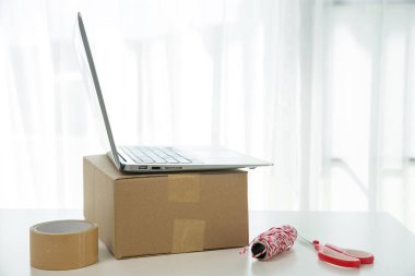 KOBİ 'nin internet işleri, teslimat bilgisayarları, barkodlar, kutular, hisse senetleri ve karton paketlerdeki ürünleri kontrol etmek için gerekli malzemeler. Ev ofisinde çalışan küçük bir işletme. teslimat hizmeti ürünü evde.