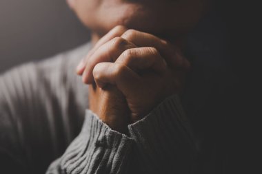 İsa dini ve Hıristiyanlık ibadeti ya da dua kavramı. Hıristiyan katolik kadın kilisede karanlıkta Tanrı 'ya dua ediyor. Dua eden kişi siyah arka planda. Kız İsa 'ya inanıyor ve inanıyor..