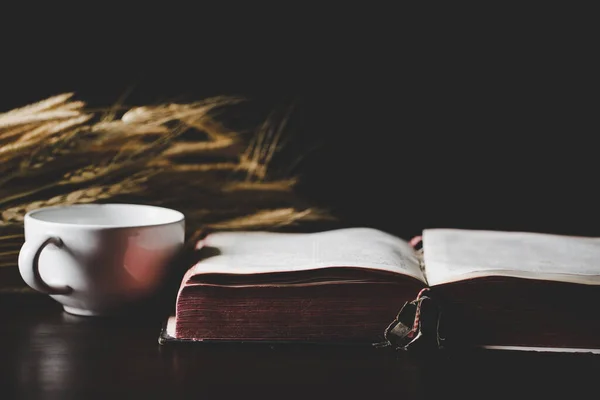 Holy bible book with paper for education on black wooden background. Christian catholic with protestant worship and pray in church. Concept of learning about faith god and religion, jesus spiritual.