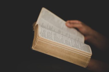 Evde ders çalışarak İncil 'i tutan genç bir kadın. Kilisede yetişkin bir Hıristiyan kadın kitap okuyor. Din maneviyatını Tanrı 'ya dua ederek öğrenen bir kız. Öğrenci eğitimi inancı kavramı.