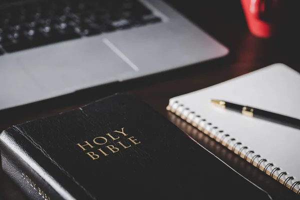 Holy bible book with paper for education on black wooden background. Christian catholic with protestant worship and pray in church. Concept of learning about faith god and religion, jesus spiritual.