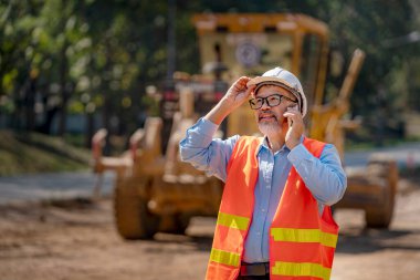Mühendis Mühendis Mühendis Mühendis İş Ekibi yeni inşaat alanında planı tartıştı. Otoyol inşaatında yol yapım makineleri. Yüksek zemin ağır sanayi ve güvenlik kavramı.