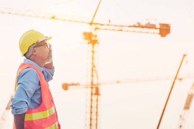 Mühendis İnşaat Mühendisi Teknisyeni İş Ekibi yeni inşaat alanında planı tartıştı. Otoyol inşaatında yol yapım makineleri. Yüksek zemin ağır sanayi ve güvenlik kavramı.