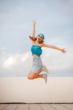 Dövmeli güzel bir moda kızı. Kırpık Üstlü İnce Kadın 'ın portresi. Güzel Kadın Gök mavisi ile duruyor En iyi moda kataloğu konsepti.