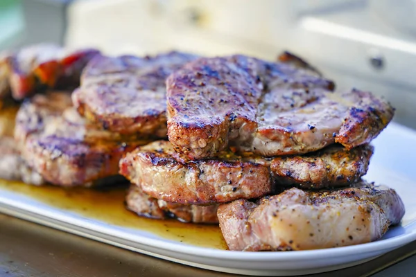 夏季野餐烧烤用白盘上的盐和黑胡椒粉配上烧焦的汁炖肉烤肉 — 图库照片#