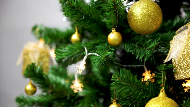 クリスマスホリデービデオ 黄金の装飾と手でクリスマスツリーを飾る女性 近くで撃たれた — ストック動画