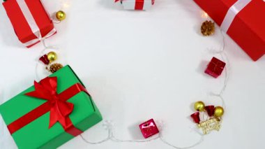 Bir kadın, içinde Noel süsü ve beyaz arka planda hediye kutuları olan bir hediye kutusu veriyor. 4k video Noel konsepti.
