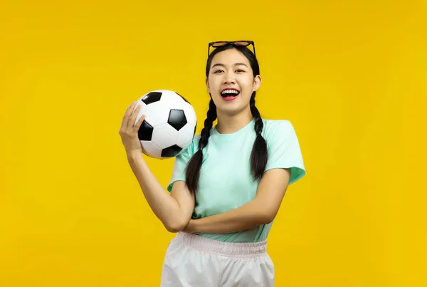 Happy Asian Jonge Vrouw Geïsoleerde Gele Achtergrond Met Een Voetbal — Stockfoto