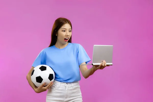 Zaskoczony Azji Młoda Kobieta Odizolowanym Różowym Tle Trzyma Piłkę Nożną — Zdjęcie stockowe