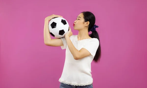 Azji Młoda Kobieta Odizolowanym Różowym Tle Gospodarstwa Całuje Piłkę Nożną — Zdjęcie stockowe