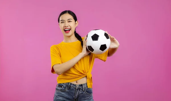 サッカーボールを保持し カメラ スポーツや人々の概念を見て隔離されたピンクの背景の上に幸せなアジアの女の子サッカーファン — ストック写真
