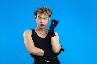 Kırmızı dudak nemlendiricisi ve siyah atletli Asyalı eşcinsel portresi. Transseksüel erkek, mavi arka plan izole edilmiş. LGBTQ + kavramları