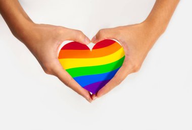 Gay gurur konsepti. Eşcinsel gururuyla el işareti yapan LGBT gökkuşağı kağıdı, beyaz arka planda kalbi kesti.