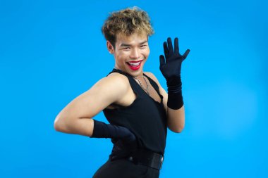 Kırmızı dudak nemlendiricisi ve siyah kolsuz bluzlu, mavi arka planı olan hoş bir gay. Transseksüel LGBTQ + kavramları