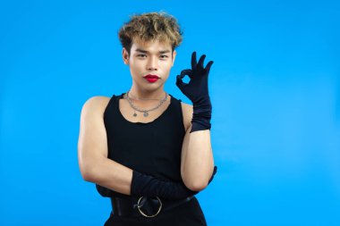 Asyalı eşcinsel bir adamın portresi. Mavi arka planda güzel bir jest. Transseksüel Gay Gururu LGBTQ + kavramları